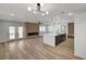 Open-concept living room with wood floors, fireplace, modern lighting, and sliding glass doors at 4804 El Tesoro Ave, Las Vegas, NV 89121