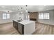 Open-concept living space featuring a modern kitchen island, lighting, and accent wall at 4804 El Tesoro Ave, Las Vegas, NV 89121