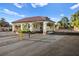 Gated entrance with white pillars, a tile roof, and well-maintained landscaping at 5009 Elm Grove Dr, Las Vegas, NV 89130