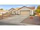 View of a single-story home featuring a tile roof, desert landscaping, a wide driveway, and an attached two-car garage at 5009 Elm Grove Dr, Las Vegas, NV 89130