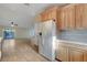 Open kitchen featuring light wood cabinets, white refrigerator, neutral backsplash and tile flooring at 602 Paloma Dr, Boulder City, NV 89005