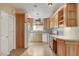Well-lit kitchen featuring light wood cabinets, tiled backsplash, tile floors, and modern white appliances at 602 Paloma Dr, Boulder City, NV 89005