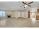 Spacious living room with tile floors, a brick fireplace, a ceiling fan, and natural light from shuttered windows at 602 Paloma Dr, Boulder City, NV 89005