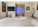 Luxurious bathroom features a large soaking tub, tv, and a chandelier above the tub at 7600 Pleasant Colony Ct, Las Vegas, NV 89131