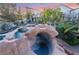 Resort-style pool with water slide, grotto, spa and view of back yard at 7600 Pleasant Colony Ct, Las Vegas, NV 89131