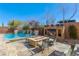 Backyard featuring a pool, fire pit, lounge chairs, and an outdoor fireplace, perfect for entertainment at 7763 Brisk Ocean Ave, Las Vegas, NV 89178