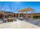 Expansive backyard with a pool, fire pit, outdoor fireplace, and patio seating under a pergola at 7763 Brisk Ocean Ave, Las Vegas, NV 89178