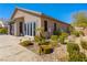 A gorgeous home exterior featuring a well-manicured yard, hardscape and a beautiful desert landscape design at 7763 Brisk Ocean Ave, Las Vegas, NV 89178