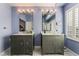 Ensuite bathroom with dual sinks, granite countertops, and blue walls with modern vanity lighting at 7837 Silver Plateau Ave, Las Vegas, NV 89128