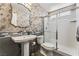 Modern bathroom featuring a stylish vanity, walk-in shower with glass door and decorative wallpaper at 7837 Silver Plateau Ave, Las Vegas, NV 89128