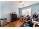 Well-lit bedroom with hardwood flooring, window shutters, desk and gaming setup at 7837 Silver Plateau Ave, Las Vegas, NV 89128