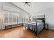 This bedroom features a large bed, many windows, and hardwood floors at 7837 Silver Plateau Ave, Las Vegas, NV 89128