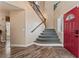 Inviting home foyer with a striking red front door, a staircase leading to the upper level, and hardwood flooring at 7837 Silver Plateau Ave, Las Vegas, NV 89128