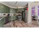 This kitchen features stainless steel appliances, granite countertops, and green cabinets at 7837 Silver Plateau Ave, Las Vegas, NV 89128