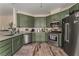 This kitchen features granite countertops, stainless steel appliances, and green cabinets at 7837 Silver Plateau Ave, Las Vegas, NV 89128
