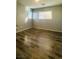 A bright bedroom with hardwood floors and natural light from two windows at 7985 Flower Seeds St, Las Vegas, NV 89139
