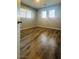A bright bedroom with hardwood floors and natural light from three windows at 7985 Flower Seeds St, Las Vegas, NV 89139
