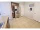 Open kitchen area with stainless steel refrigerator and pantry, tile floors, and white doors at 8957 Rufina St, Las Vegas, NV 89148