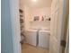 Bright laundry room with side-by-side washer and dryer, and shelving for storage at 8957 Rufina St, Las Vegas, NV 89148