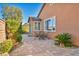 Charming backyard patio with brick flooring and cozy outdoor seating, surrounded by lush greenery at 9076 Bridal Creek Ave, Las Vegas, NV 89178