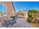 Private backyard features brick flooring, lush landscaping, wrought iron furniture, and a relaxing hot tub at 9076 Bridal Creek Ave, Las Vegas, NV 89178