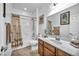 Well-lit bathroom with a vanity sink, a shower with a tub, and a stylish shower curtain at 9076 Bridal Creek Ave, Las Vegas, NV 89178