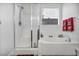 Bright bathroom featuring a glass-enclosed shower and a relaxing soaking tub by a sunny window at 9076 Bridal Creek Ave, Las Vegas, NV 89178