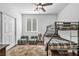 Bright bedroom with a bunk bed, ceiling fan, closet, and a window providing natural light at 9076 Bridal Creek Ave, Las Vegas, NV 89178