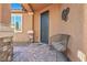 Inviting front porch with decorative wrought iron door, stylish chair, and accent wall at 9076 Bridal Creek Ave, Las Vegas, NV 89178