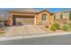 Charming single-story home showcasing a manicured front yard, brick driveway, and an attached two-car garage at 9076 Bridal Creek Ave, Las Vegas, NV 89178