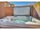 Relaxing hot tub featuring hydrotherapy jets, surrounded by a brick patio and privacy wall at 9076 Bridal Creek Ave, Las Vegas, NV 89178