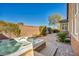 Outdoor spa/hot tub with beautiful stone accents, integrated into a relaxing brick patio and lush landscaping at 9076 Bridal Creek Ave, Las Vegas, NV 89178