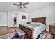 Spacious primary bedroom with a large bed, classic furniture, a ceiling fan, and a peek into a walk-in closet at 9076 Bridal Creek Ave, Las Vegas, NV 89178