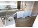 Well-lit bathroom featuring a spacious vanity, dual sinks, mirror, and modern wood-look flooring at 9424 Fox Forest Ave, Las Vegas, NV 89129