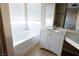 Sunlit bathroom showcasing a bathtub, white vanity, and stylish wood-look flooring for a serene retreat at 9424 Fox Forest Ave, Las Vegas, NV 89129