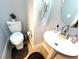 Bright powder room with a pedestal sink, round mirror, and stylish towel bar at , Las Vegas, NV 89183