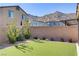 The backyard of this home has artificial turf, a brick wall, and desert landscaping providing a low maintenance outdoor space at 10785 Wild Parsley Ave, Las Vegas, NV 89129