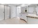 A spacious bathroom featuring double sinks, tile floors, and a glass-enclosed shower for a modern and clean aesthetic at 10785 Wild Parsley Ave, Las Vegas, NV 89129