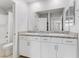 Bright bathroom featuring dual sinks with white cabinets and granite countertops at 10785 Wild Parsley Ave, Las Vegas, NV 89129