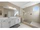 Bright main bathroom featuring double vanity, large mirror, and frameless glass shower at 1091 E Sunset Rd, Henderson, NV 89011