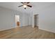 Bright bedroom with wood-look flooring, ceiling fan, and ensuite bathroom access at 1163 Tumbling River Ave, Henderson, NV 89052