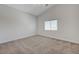 An empty bedroom offers neutral colored walls, carpet flooring, and natural light from the window at 1163 Tumbling River Ave, Henderson, NV 89052