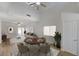 Staged living room featuring vaulted ceilings, fan, and sliding doors to the backyard at 1163 Tumbling River Ave, Henderson, NV 89052