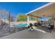 Inviting covered patio featuring comfortable seating around the pool and decorative stone pathway at 1163 Tumbling River Ave, Henderson, NV 89052