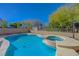 Inviting backyard pool with a hot tub surrounded by lush landscaping and clear blue sky at 1163 Tumbling River Ave, Henderson, NV 89052