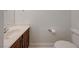 Neutral powder room with wood vanity, white counter and modern toilet at 1163 Tumbling River Ave, Henderson, NV 89052