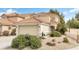 Charming two-story home with a tile roof, two-car garage, and beautifully landscaped front yard featuring desert plants and rocks at 1216 Maserati Dr, Las Vegas, NV 89117