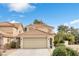 Front exterior features two-story layout, neutral stucco, tile roof, attached garage, and desert landscaping at 1216 Maserati Dr, Las Vegas, NV 89117