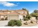 Charming two-story home features neutral stucco, tile roof, attached garage, and desert landscaping at 1216 Maserati Dr, Las Vegas, NV 89117