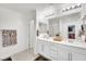 Bright bathroom featuring double sinks, white cabinetry, and walk-in closet at 12541 Lylan Ridge St, Las Vegas, NV 89138